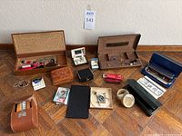 Full view of all items organized on floor showing boxes, knife, pens, brushes, keys and containers in a single image.