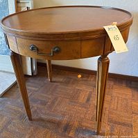 Front view showing round top, drawer and fluted legs