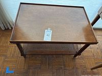 Top view of the rectangular dark wood side table showing the smooth surface with raised lip edges and measurement sticker on top.