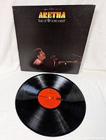 Vinyl record disc showing orange label and vinyl surface.