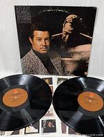 Photo of both vinyl records and the album cover of Kenny Burrell Ellington Is Forever Volume One showing record labels and cover art.