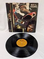 Vinyl record and sleeve cover with artistic image and text 'Neil Young' and 'American Stars And Bars'