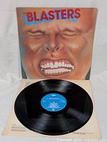 The Blasters vinyl record partially pulled out of album cover showing blue label on the black vinyl disc and face artwork cover.