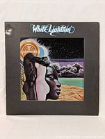 Front cover of White Lightning vinyl LP showing illustrated artwork of faces with cosmic/desert background