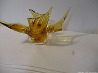 Side view of amber chalet style glass centerpiece showing elongated curved points and translucent amber color.