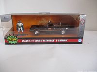 Front view of the packaging with Batmobile and Batman figure, showing the product branding and condition.