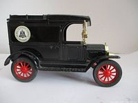 Side view of black vintage die cast truck bank with Bell Telephone decal and red wheels