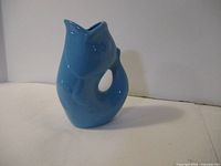 Side view of blue ceramic gurgle pot showing fish shape and spout