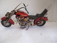 Front side view of 16-inch metal motorcycle model showing detailed engine, flame decals, and black textured seat.