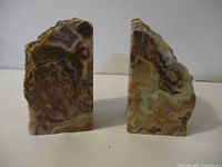 Front angled view of two stone bookends showing natural banded patterns and rough top edges