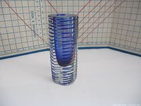 Front view of the vase showing vertical and horizontal blue stripe pattern on clear glass with ruler showing approximate 8 inch height.