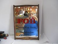 Full view of the vintage F.O.B. Canadian Whisky mirror tray with ship emblem and wooden frame