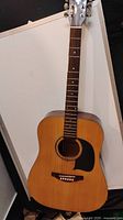 Full front view of vintage George Washburn Lyon LG2TPAK acoustic guitar with natural wood finish and black pickguard.