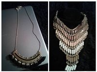 Photo of two vintage necklaces, one with a metallic and black semi-circular pendant on a thin chain, and the other multi-strand beaded bib necklace with neutral colors.