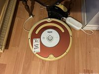 Full view of the iRobot Roomba vacuum on the floor with charging dock in background