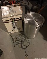 Full view of the large stainless steel pot with lid, bird rack, and original box in background.
