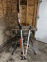 Full view of WorkMate bench with garden pruners and pole saw extension arm shown in a garage setting.