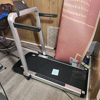 Full side view of the treadmill showing the running belt, frame, and handrails.