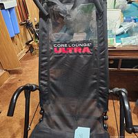 Front view of the workout chair with Core Lounge Ultra branding on mesh backrest.