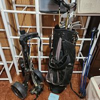 Full view of the golf bag filled with clubs and the Bag Boy M-30 push cart beside it showing both items together.
