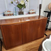 Front view of closed teak sideboard credenza showing overall shape and finish