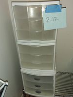 Photo showing one complete set of three stacked white plastic storage drawers with translucent fronts and white frame.