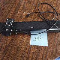 ZVOX sound bar with digital display and power cord on brown floor, listing number 249 visible.