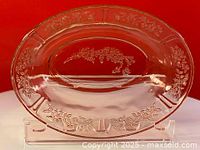 Top-down view showing the entire oval bowl and detailed etched floral rose pattern around inner rim and base center.