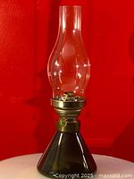 Full view of vintage glass oil lamp showing smoke-colored glass base, clear glass chimney, and metal burner.