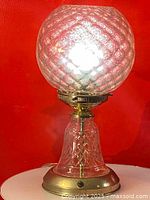Full view of vintage glass table lamp with illuminated globe showing textured diamond pattern.