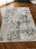 Full view of the carpet showing overall pattern and size on wooden floor.