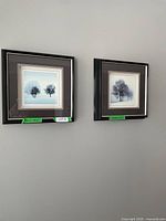 Overview of two framed winter tree photographic prints on a wall.