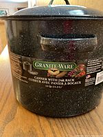 Photo of Granite-Ware canner showing label and handles, black granite speckled finish, 12 quarts capacity.