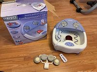 Homedics Foot Rejuvenator Ultra device next to product box on wooden floor.