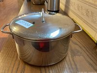 Closed stainless steel pot with lid, showing overall pot shape, side handles, and lid handle.