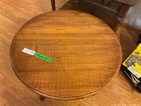 Close-up image of the round wooden occasional table's surface showing wood grain texture and natural finish.