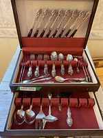 Full view of the Oneida silverplate cutlery set neatly arranged in the wooden chest showing multiple forks, knives, spoons, and specialty pieces.