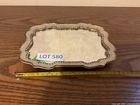 Small rectangular mirrored tray shown on wood surface with a measuring tape indicating length