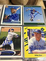 Close-up of four autographed baseball cards featuring Mark Whiten, Todd Steverson, Fraser, and Willie Blair, showing signature details and condition
