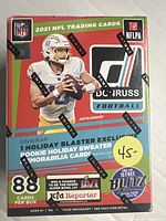Front view of sealed 2021 Donruss NFL trading card box featuring Justin Herbert with Panini branding and promotional text about holiday blaster and collectible cards.