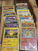 Top view of sleeved cards showing Pikachu, Victini, Eevee, Charmander and other foil cards