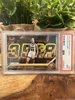 Front of the PSA graded Caitlin Clark 2023 Bowman University Now basketball card showing record points scoring and Iowa jersey.