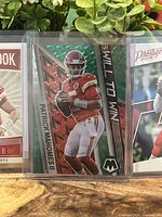 Close-up front of Will to Win Green Mosaic Prizm card featuring Patrick Mahomes in Chiefs uniform, highlighting holographic green zigzag pattern.