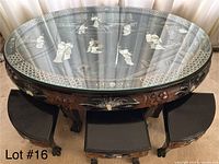 Round black lacquer low table with six matching stools tucked underneath, mother-of-pearl inlay and carved legs