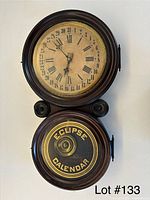 Front view of Ingraham 31-day wall clock showing upper time dial and lower Eclipse calendar dial