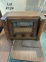 Photo of a vintage wooden tabletop radio with AM dial and three knobs, showing front view.