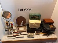 Full view of lot showing vintage razors including electric razor, three different mirrors, shaving brushes, multiple razor cases, and grooming accessories arranged on a tiled surface.