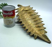 Top angle view of bronze fern dish next to a Campbell's soup can for scale.