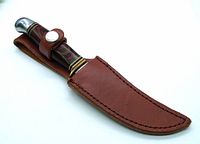 Tomahawk hunting knife inside brown leather sheath showing overall design and condition.