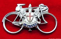 Front view of vintage bicycle travel pin featuring the City of London Coat of Arms with red cross and two griffins, against a red background.